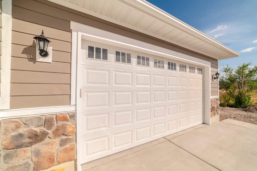 White double garage door on modern home during sunny day