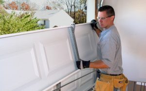 Contractor setting garage door panel into frame