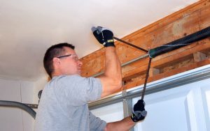 Contractor setting winding bar on garage door