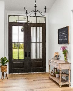 Entry way door from inside of home with windows on each side letting in large amount of natural light